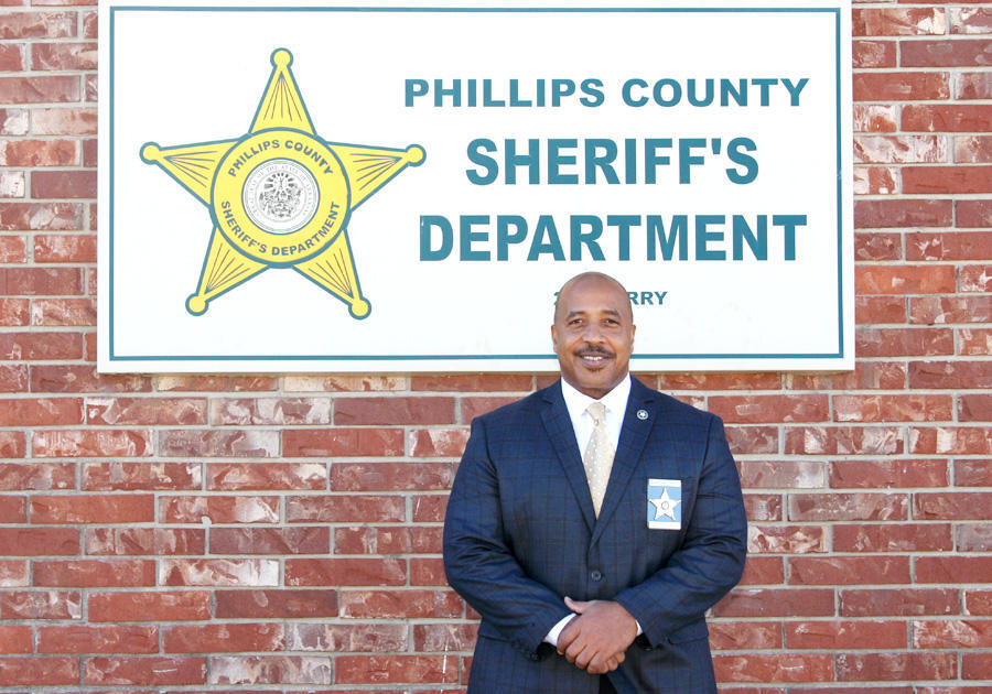 Sheriff Neal Byrd standing in front of Phillips Sheriff's Office sign